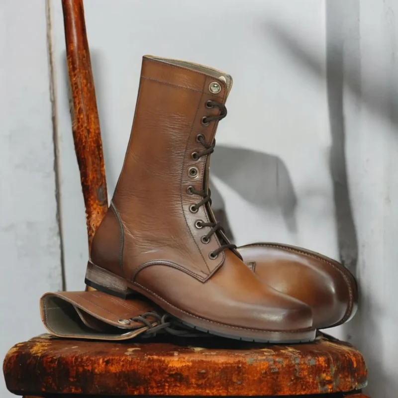 Men's tan ankle-high leather boots with lace-up design and durable buffalo sole.