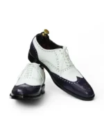 Close-Up of Brogued Detailing on Black and White Wingtip Shoes